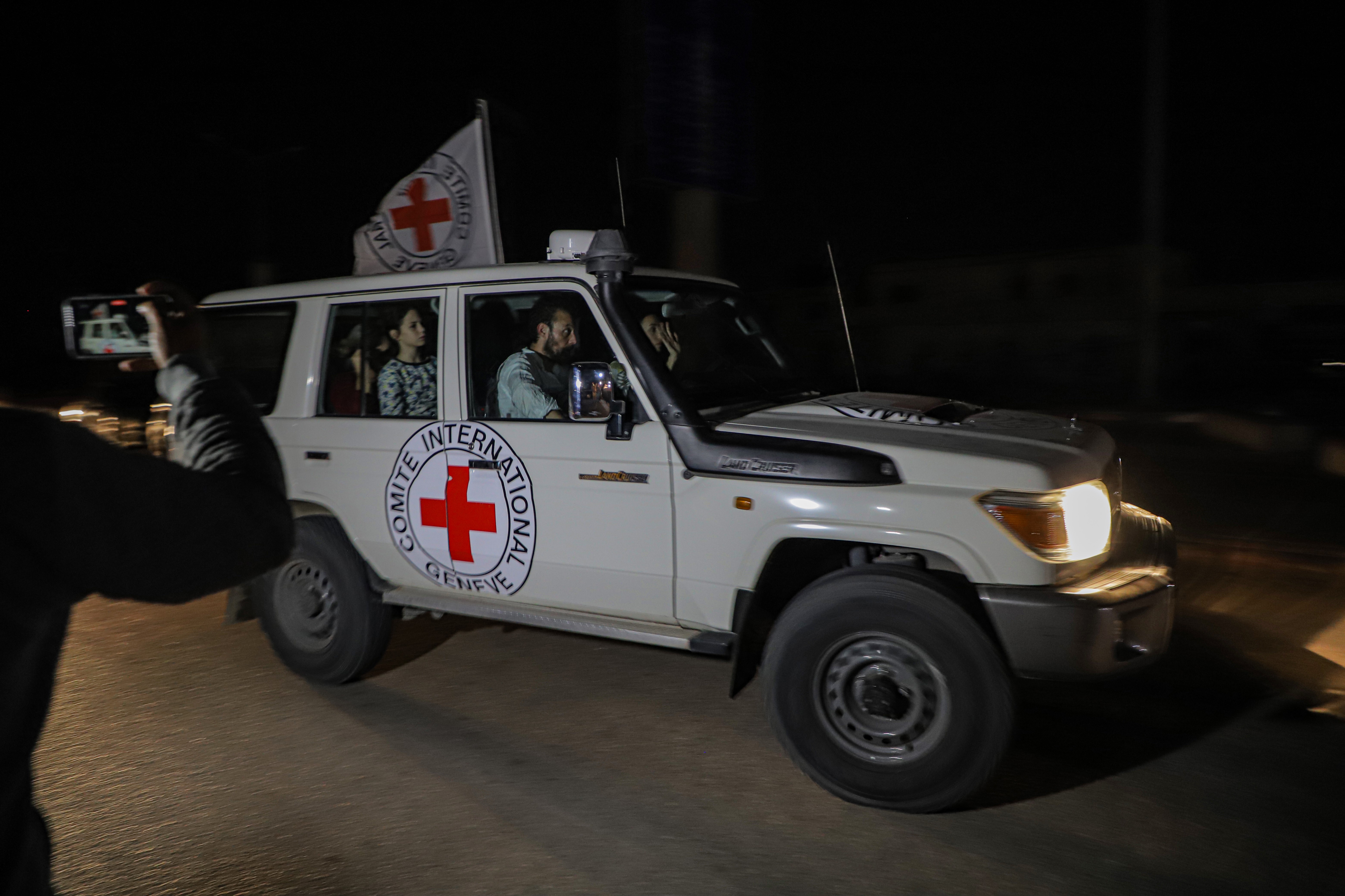 A Red Cross vehicle driving at night.